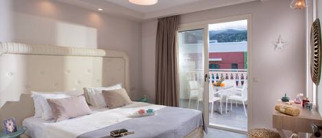 Habitación de hotel con una cama grande, una mesita de noche con lámpara y vistas al balcón exterior.