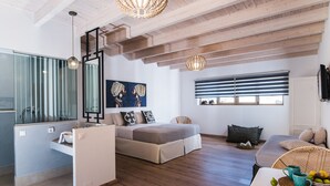 Uma sala de estar moderna com uma cama, um sofá, uma mesa de jantar e uma cozinha.
