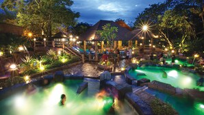 A nighttime outdoor pool area with multiple water features and illuminated structures. - Golden Roof Hotel Sunway Ipoh (Ipoh)