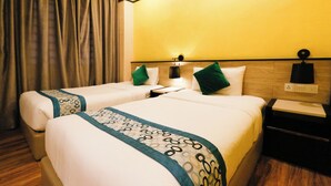 Ein Hotelzimmer mit zwei Betten, jeweils mit Kissen und einem Nachttisch.