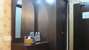 A bathroom with a wooden vanity, a mirror, and toiletries. - Classic Kinabalu Hotel (Kota Kinabalu)