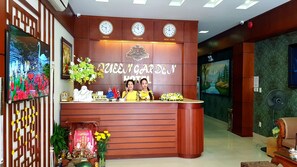 A hotel reception desk with clocks indicating Paris, Vietnam, and New York times. - Queen Garden Hotel (Ho Chi Minh City)