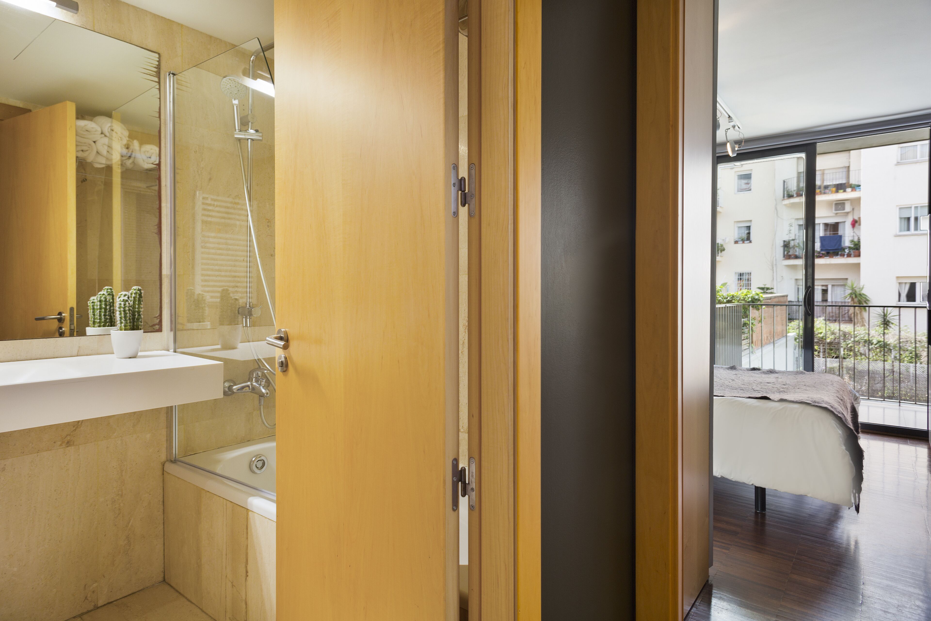 Un baño moderno con ducha, lavamanos y un espejo grande.