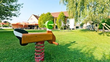 Ein Spielplatz mit Schaukel und Rutsche.