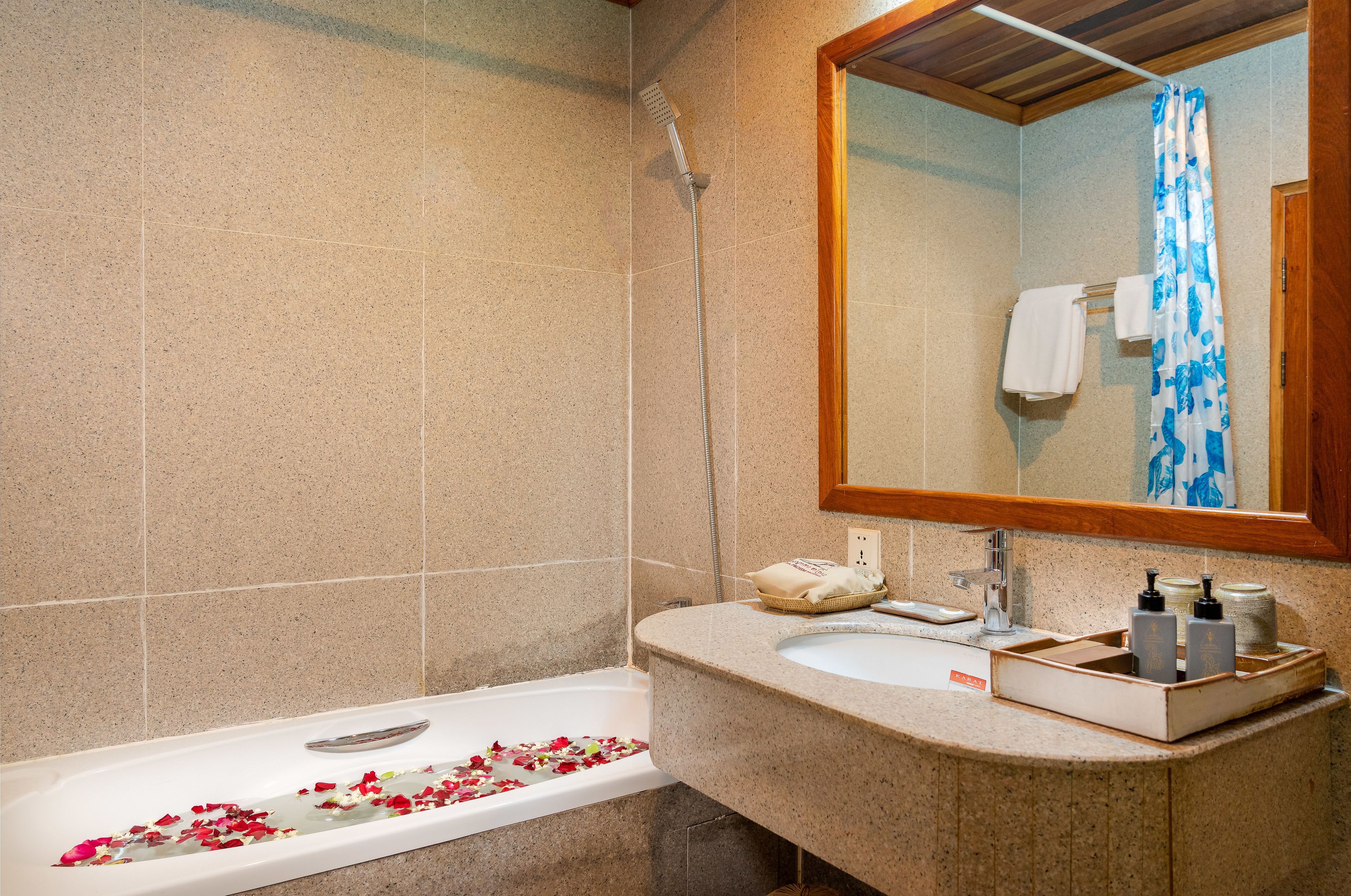 Un baño con bañera, ducha, lavamanos y espejo.