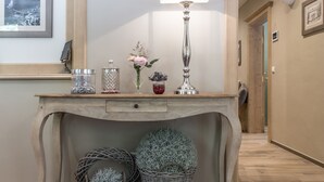 A wooden desk with a lamp, two wicker baskets, and a vase with flowers. - Pension Waldruhe (Grundlsee)