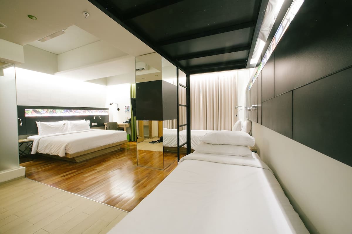 Ein Hotelzimmer mit Bett, Schreibtisch, Stuhl und Spiegel.