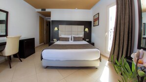 A modern hotel room with a large bed, a desk, and a chair. - Malak Hotel (Rabat)