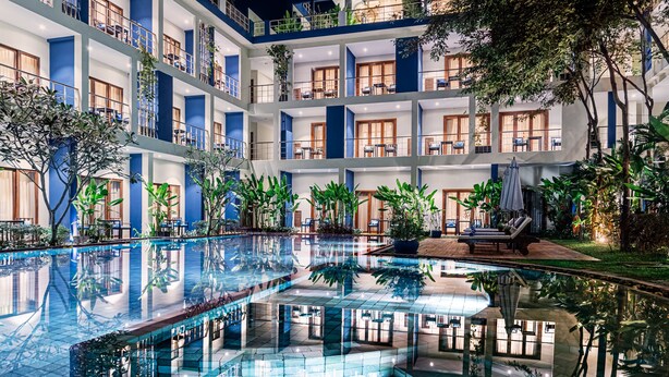 A multi-story hotel with a central pool, balconies, and indoor plants. - Sakmut Boutique Hotel (Siem Reap)