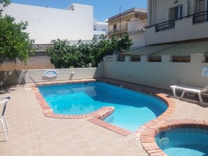 Piscine extérieure, parasols de plage, chaises longues