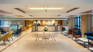 A spacious lobby with a reception desk, seating areas, and a decorative floor pattern. - Gemini Continental Lucknow (Lucknow)