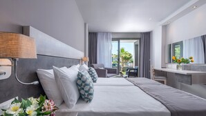 Habitación de hotel moderna con una cama grande, un escritorio y vistas al exterior.