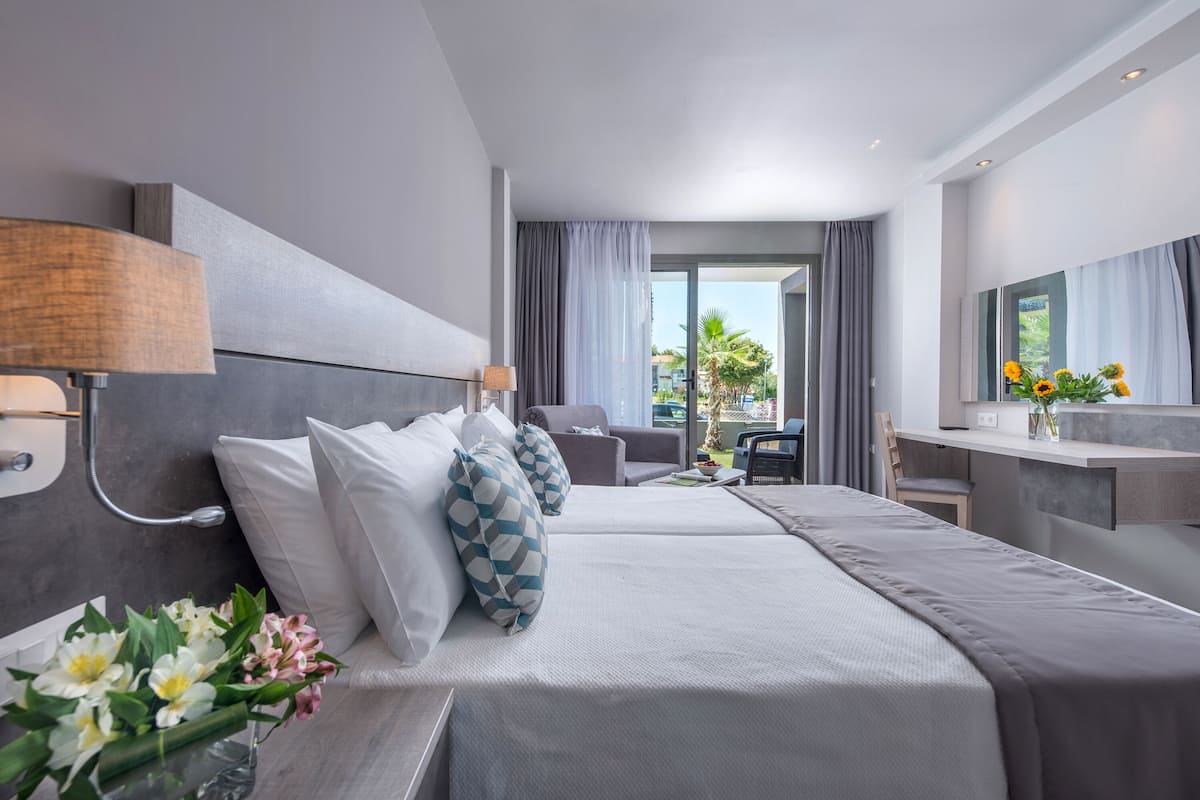 Habitación de hotel moderna con una cama grande, un escritorio y vistas al exterior.