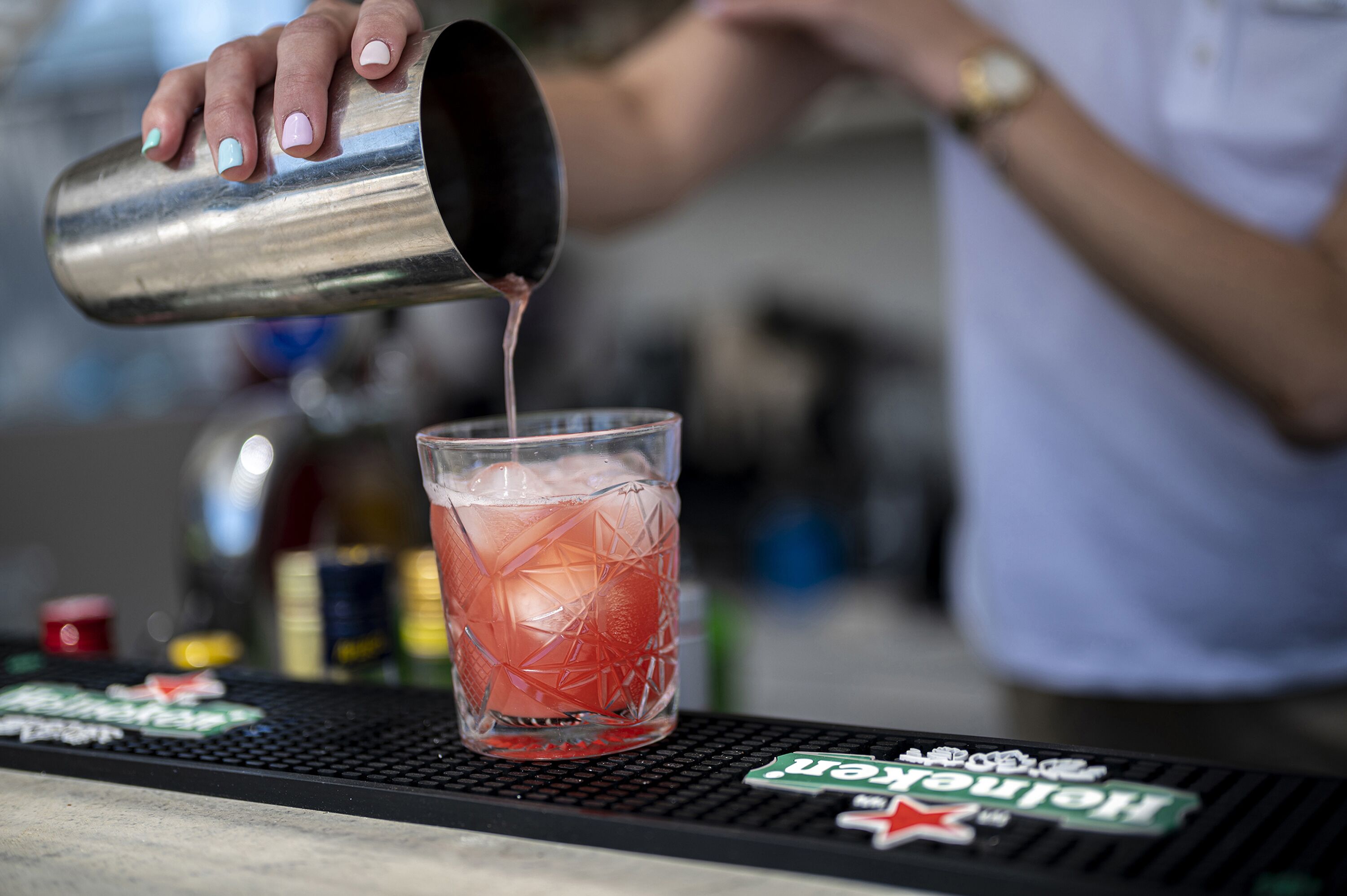 A bartender pouring a drink into a glass.