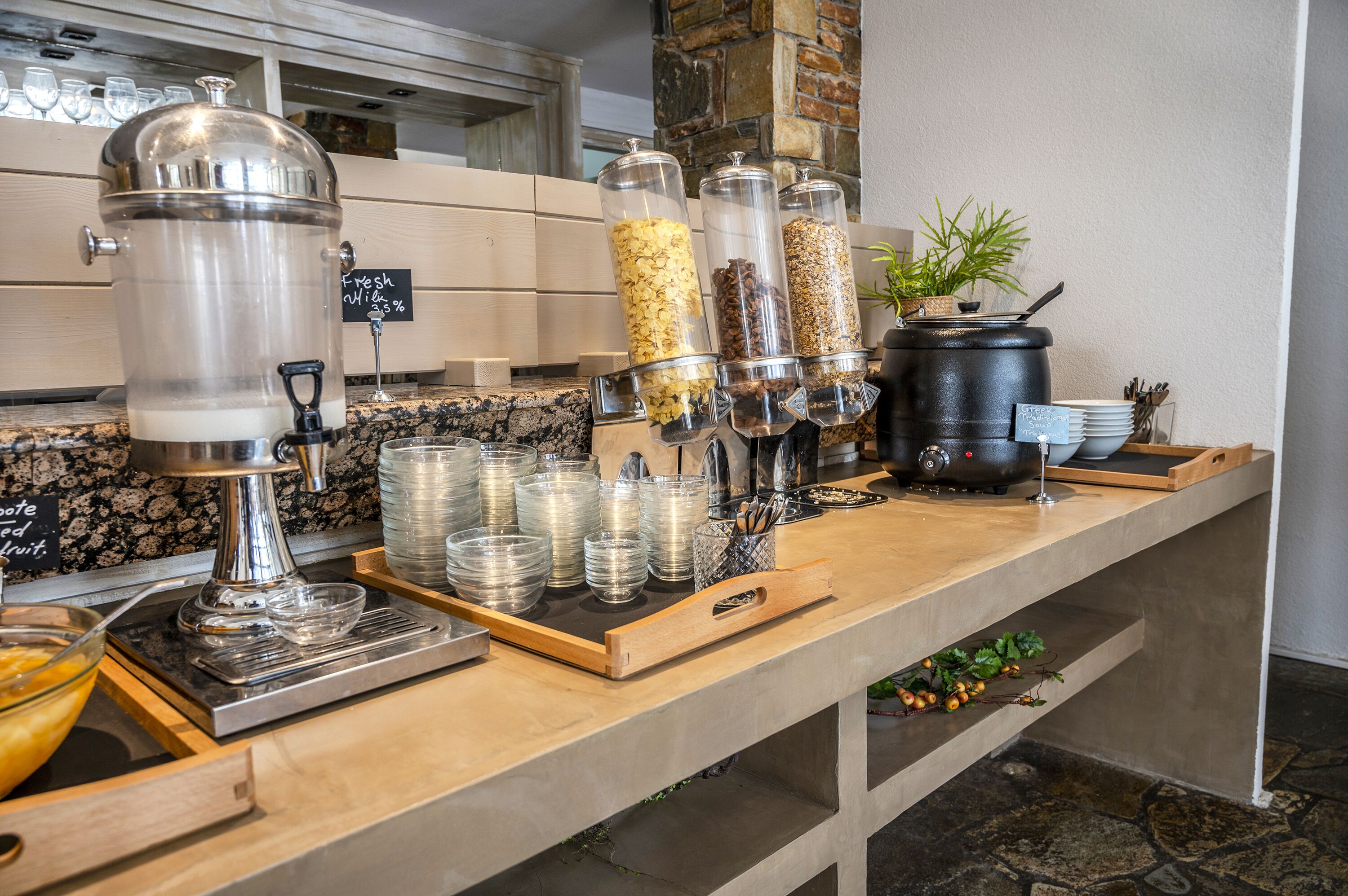 A buffet setup with a coffee machine, various food dispensers, and a coffee pot.
