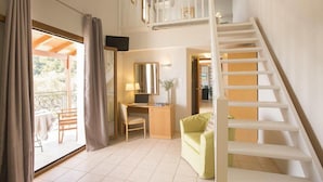 A room with a desk, chair, and a small couch. There is a staircase leading to an upper level. - Fiorella Sea View (Skiathos)