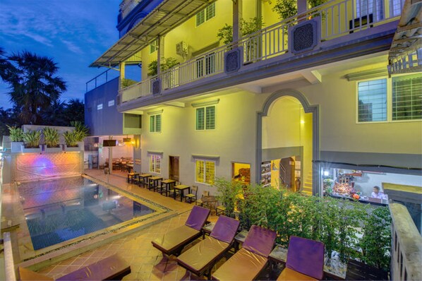 Una piscina al aire libre, sillones reclinables de piscina