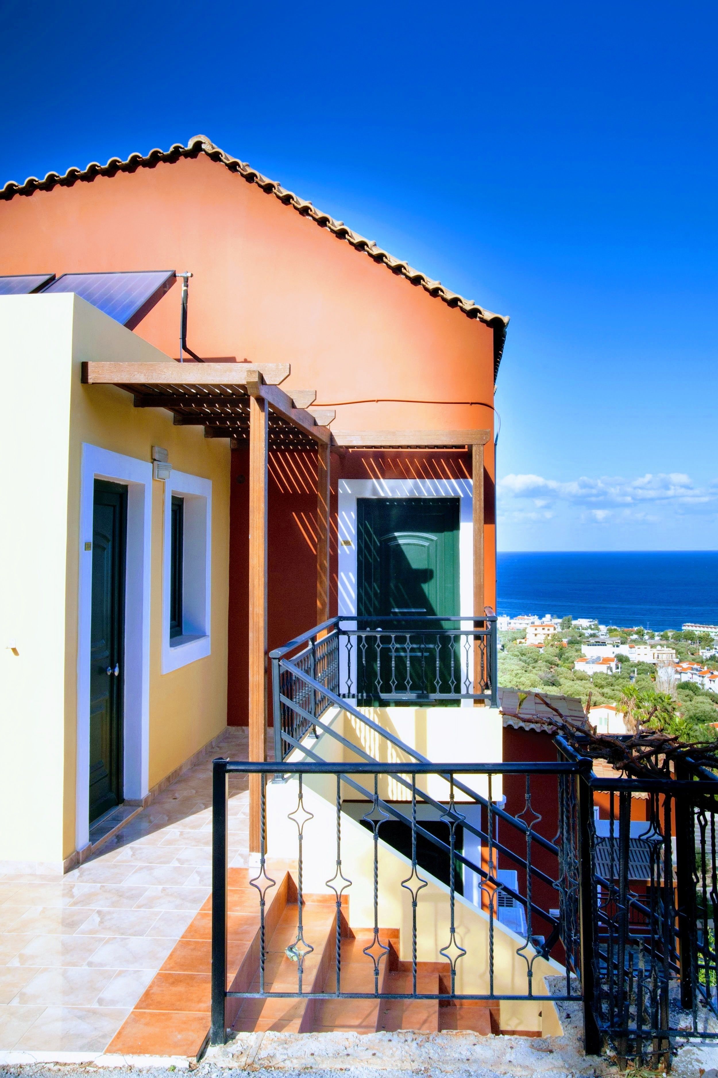 Un immeuble doté d’un balcon, d’un escalier et offrant une vue sur l’océan.