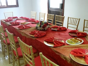 A dining table set with red napkins, gold accents, and floral centerpieces. - Hotel Atlantis 2 (Maputo)