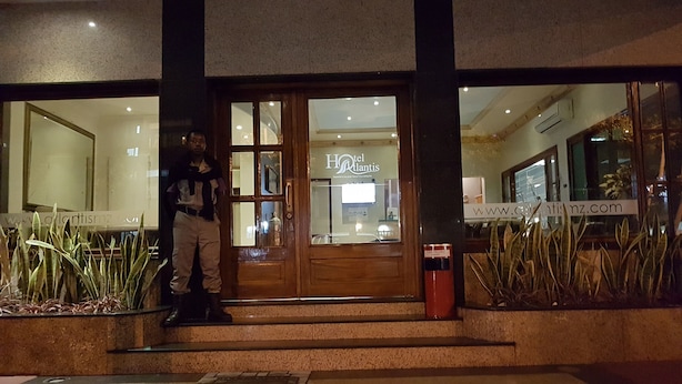The entrance of a hotel with a reception desk, a glass door, and a sign that reads "Hotel Atlantis". - Hotel Atlantis 2 (Maputo)