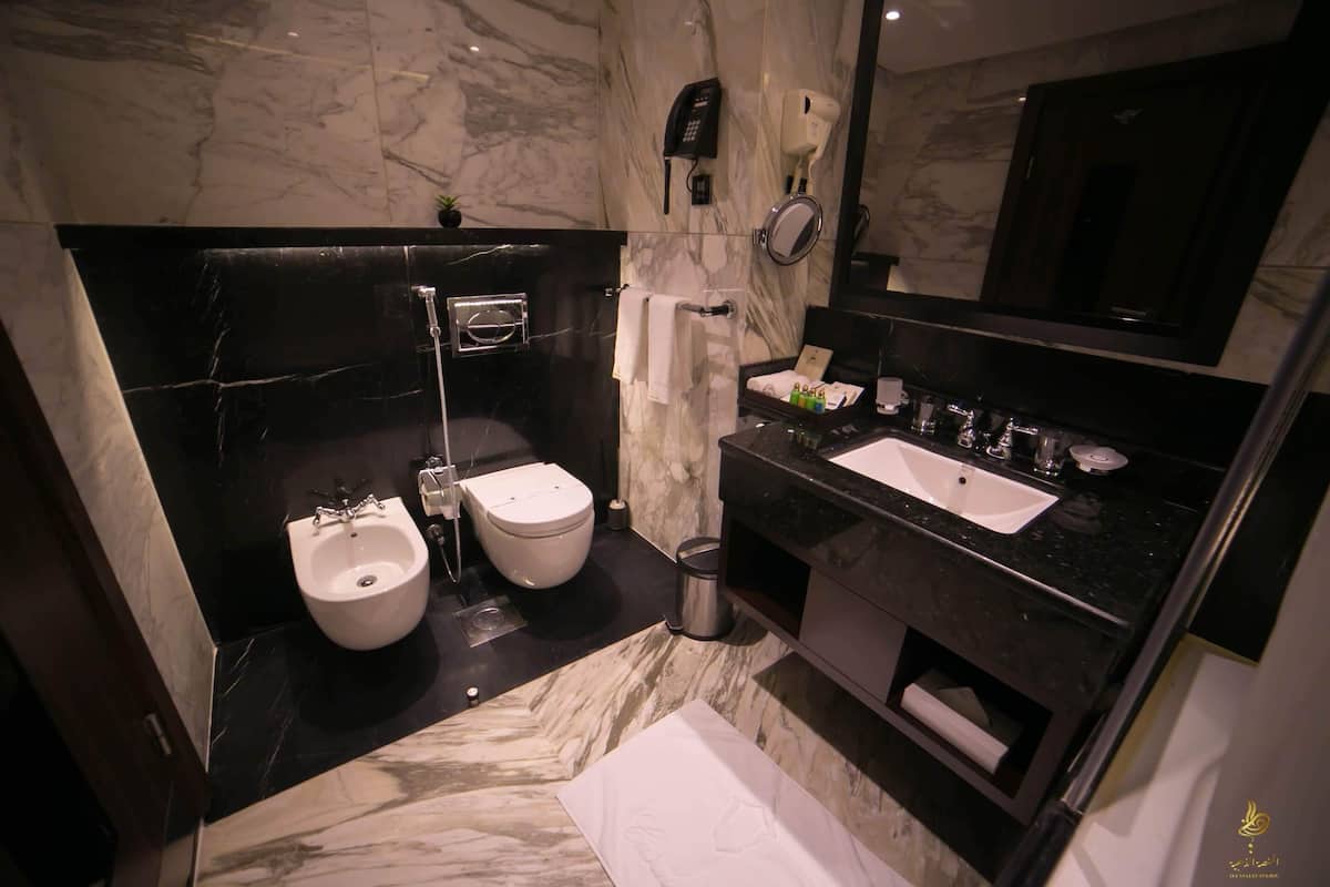 Une salle de bain moderne équipée d’un bidet, de toilettes et d’un lavabo.