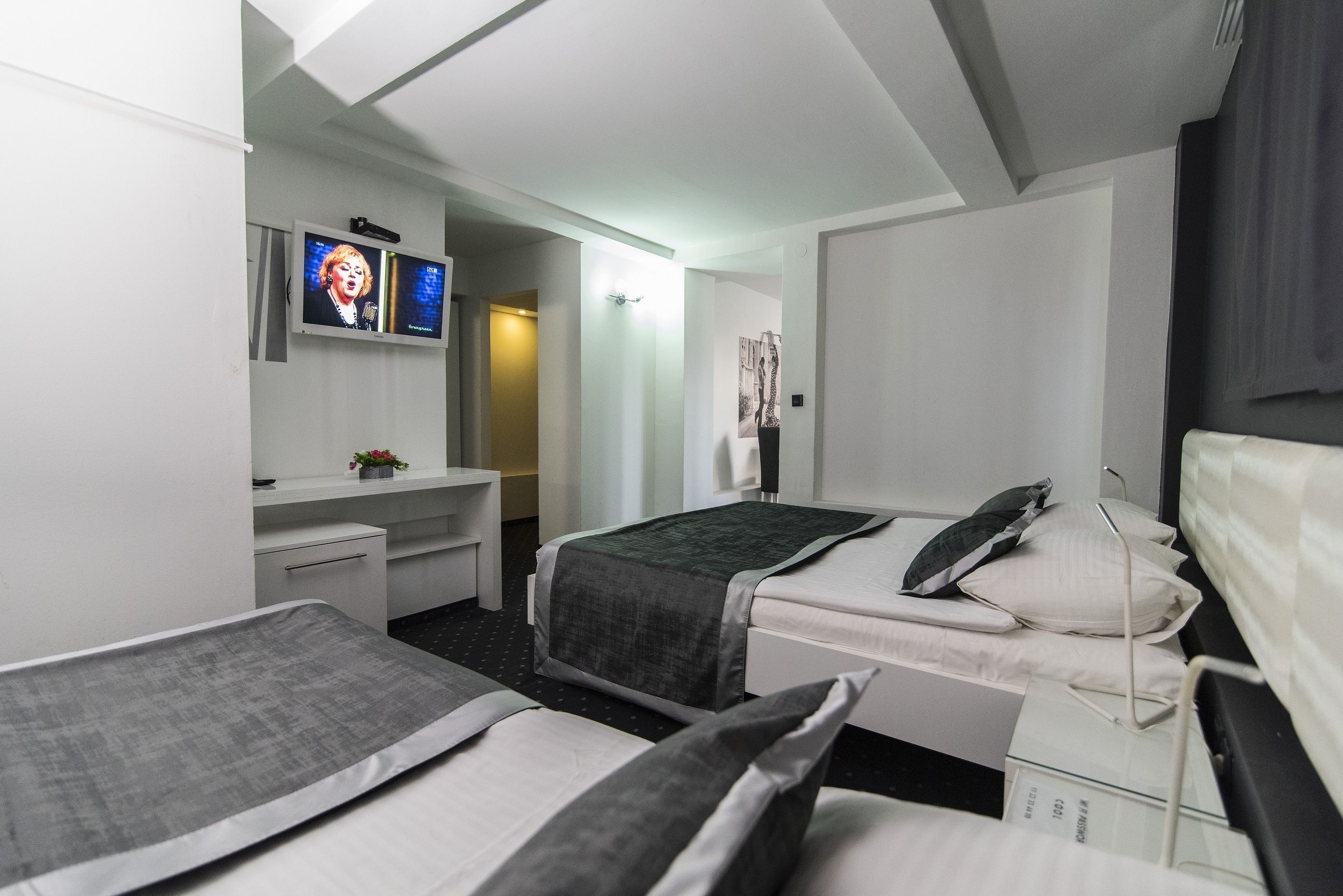 Habitación de hotel con dos camas, un escritorio, un televisor y una ventana.
