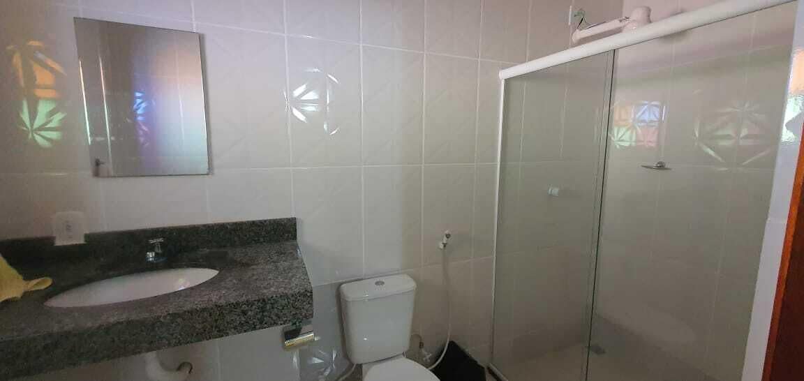 A bathroom with a sink, toilet, and glass shower enclosure.