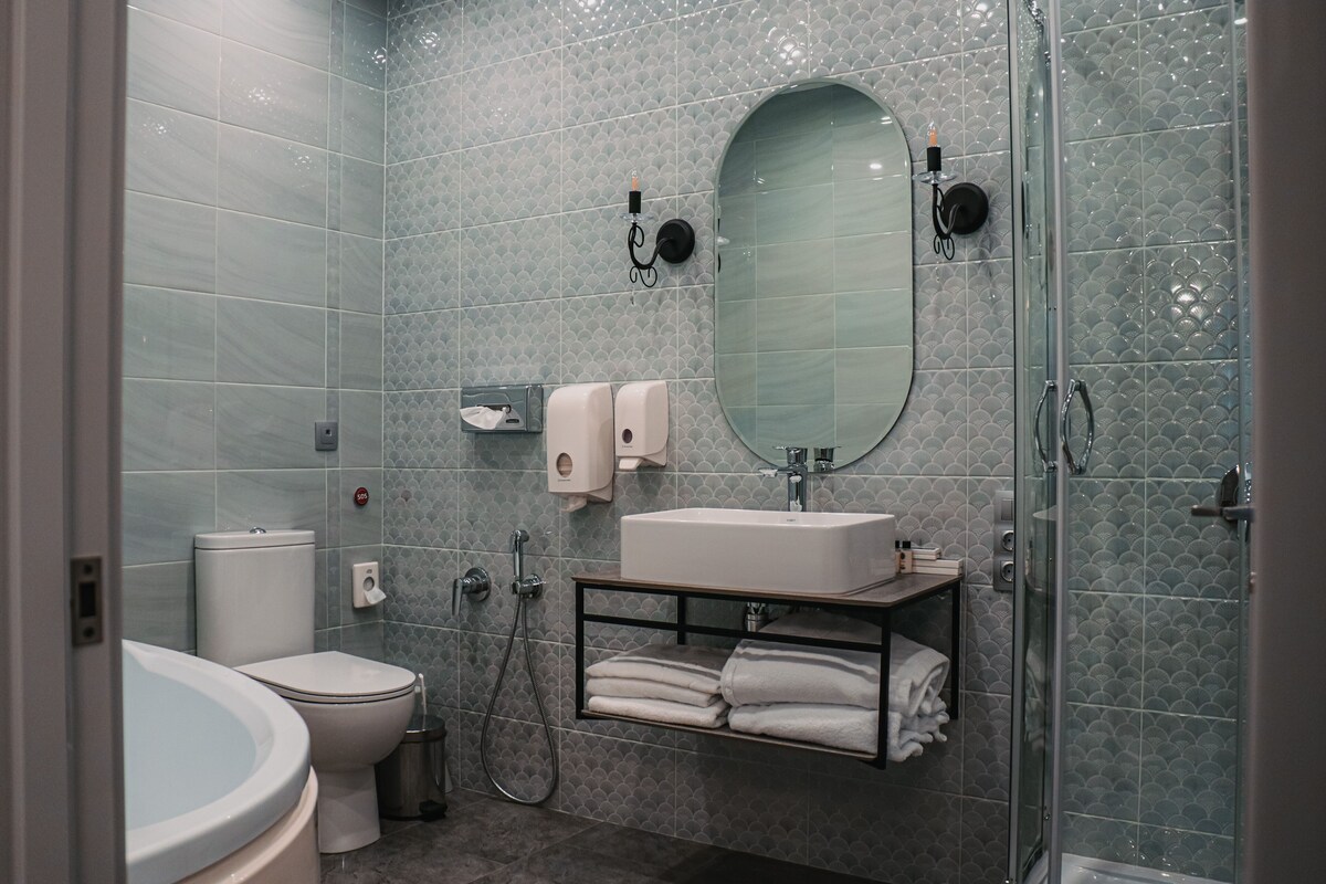 A modern bathroom with a toilet, sink, and glass-enclosed shower.