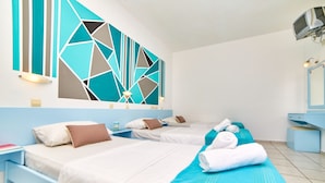 A hotel room with two beds, a large geometric wall art piece, a small desk, and a bathroom with a mirror and sink. - Village Oasis (Hersonissos)