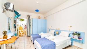 A hotel room with two beds, a small table with a pineapple, a desk, and a chair. - Village Oasis (Hersonissos)