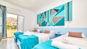 A hotel room with two beds, a large geometric wall art piece, and a balcony with a view of buildings. - Village Oasis (Hersonissos)