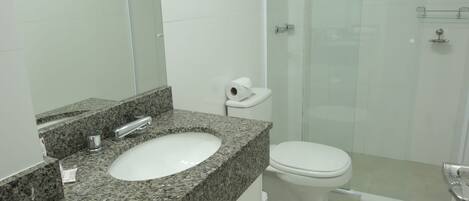 Un bagno con lavabo su piano in granito, un WC e box doccia in vetro.
