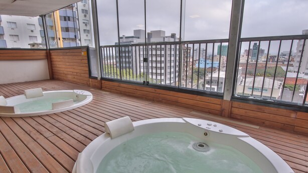 A wooden deck with two hot tubs and a city view. - Life Hotel Torres (Torres)