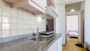 A kitchen with granite countertops, a stainless steel sink, and a built-in range hood. - Village Oasis - Annex (Hersonissos)