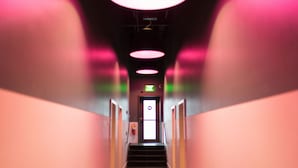 A corridor with a staircase leading to an exit door. - The 404 Hotel (Nashville)