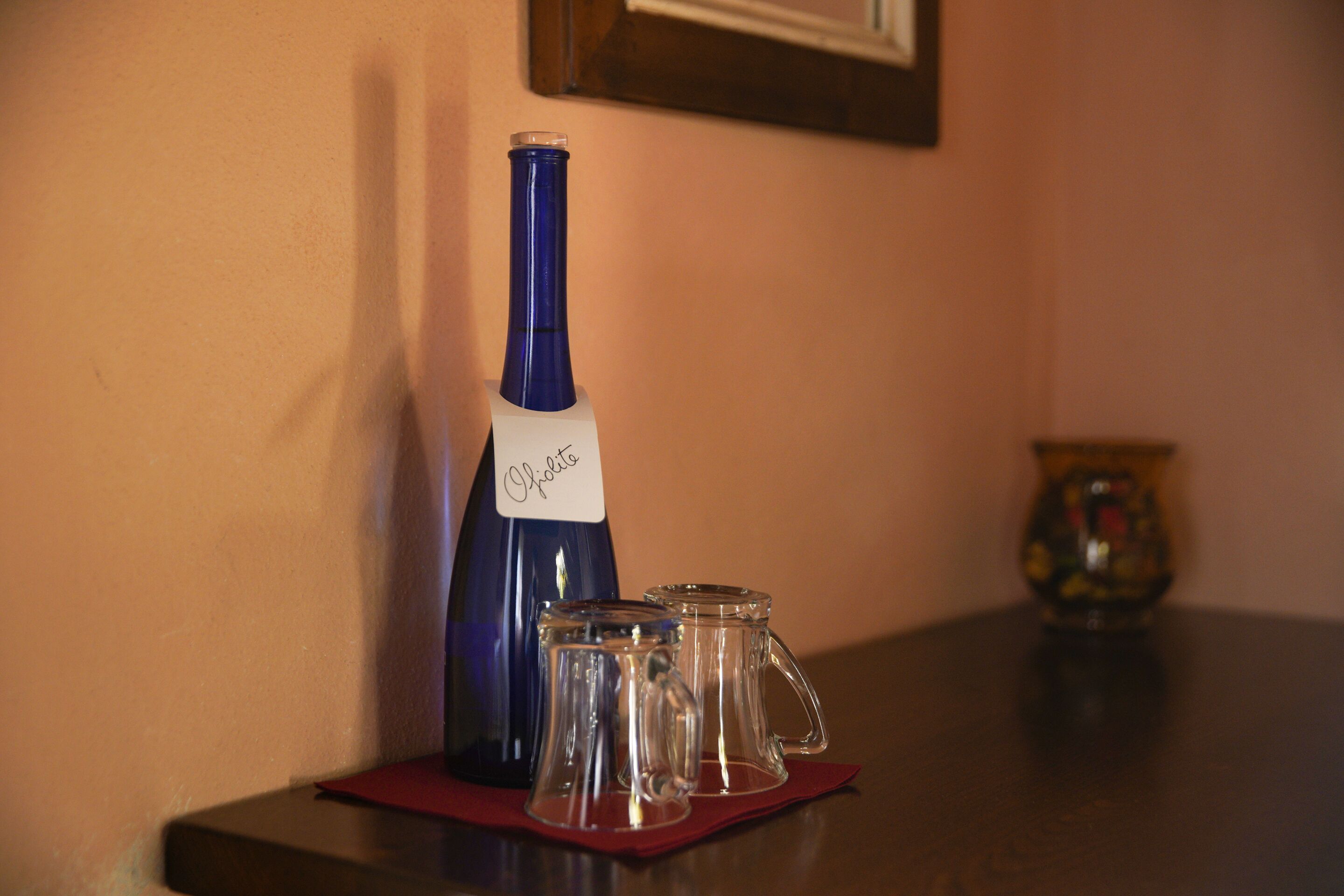 A bottle of wine and two glasses on a table.