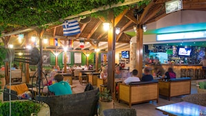 An outdoor restaurant with wicker furniture and a bar area. - Stonewell (Hersonissos)