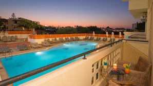 A rooftop pool with lounge chairs and a table with drinks. - Stonewell (Hersonissos)