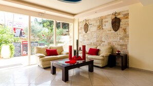 A modern living room with a sofa set, a coffee table, and decorative elements. - Stonewell (Hersonissos)