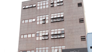 Un edificio de varios pisos con fachada de ladrillo y varias ventanas.