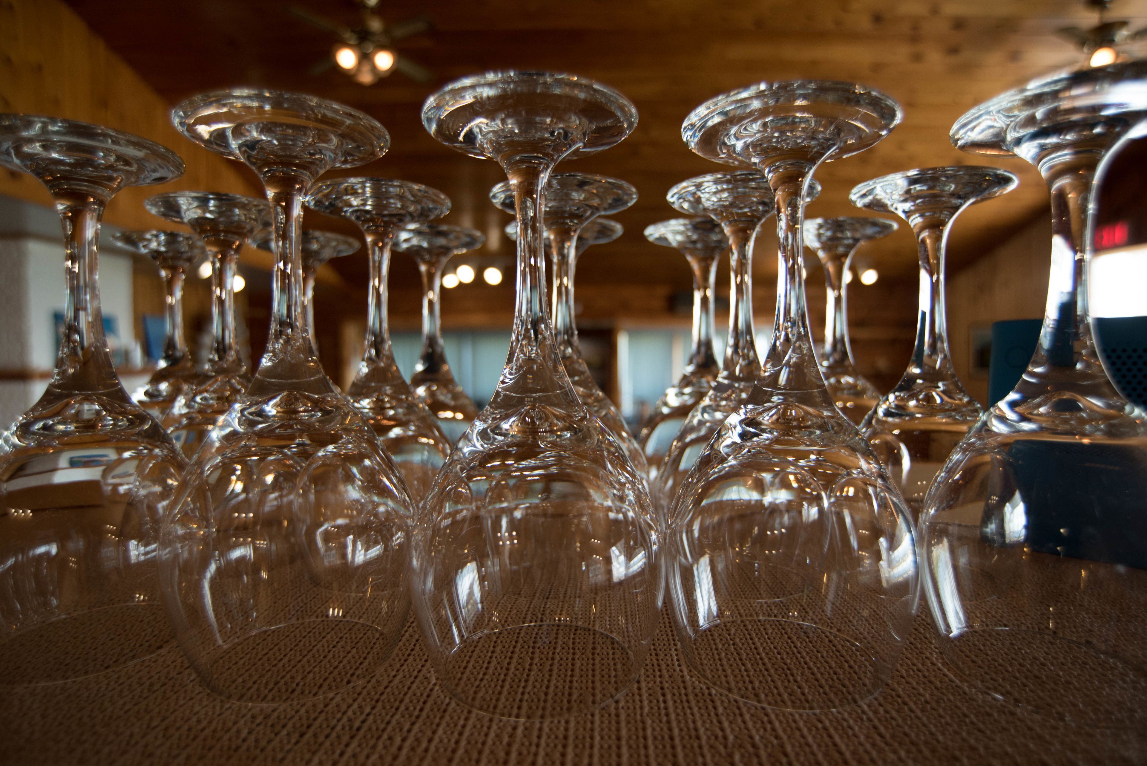 A collection of clear wine glasses arranged on a table in a wooden interior.