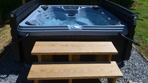 Ein Whirlpool mit einer hölzernen Sitzbank davor.