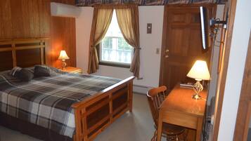 Een slaapkamer met een bed, een bureau en een stoel.