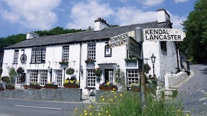 A traditional white building with a sign reading "Kendal Lancaster" and "Bowness Windermere."
