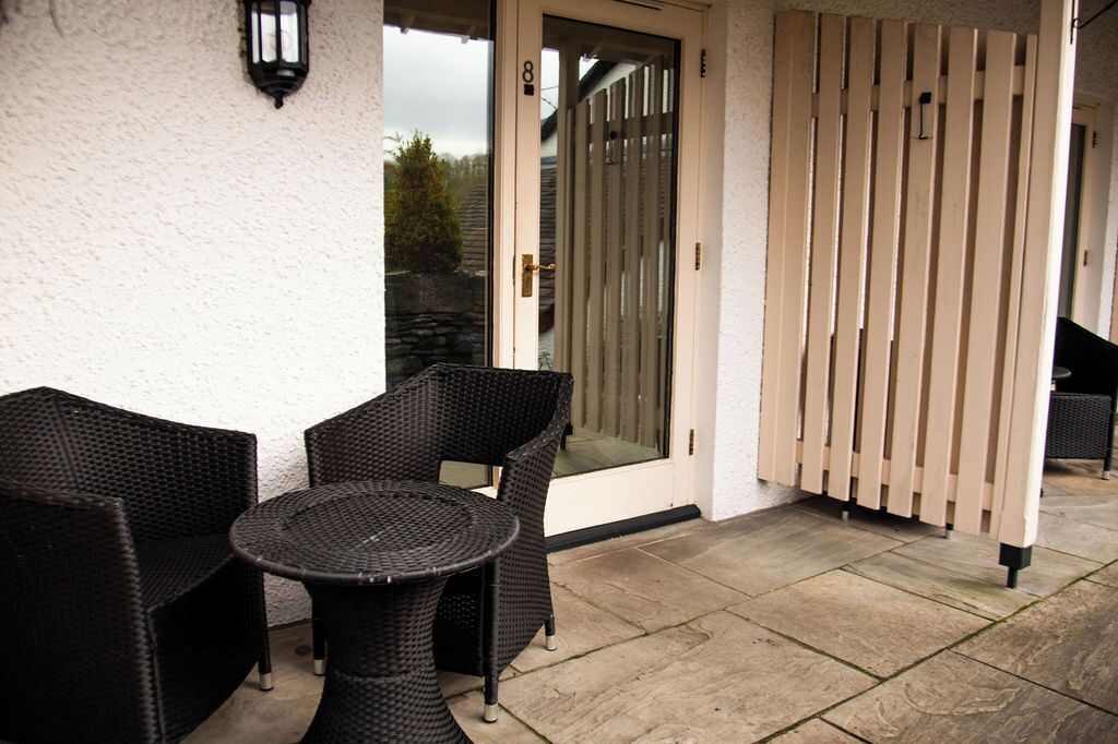 Eine Terrasse mit Korbmöbeln und einer Glastür.