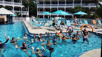 Relax by the pool surrounded by lounge chairs and umbrellas, with a secure and serene atmosphere.