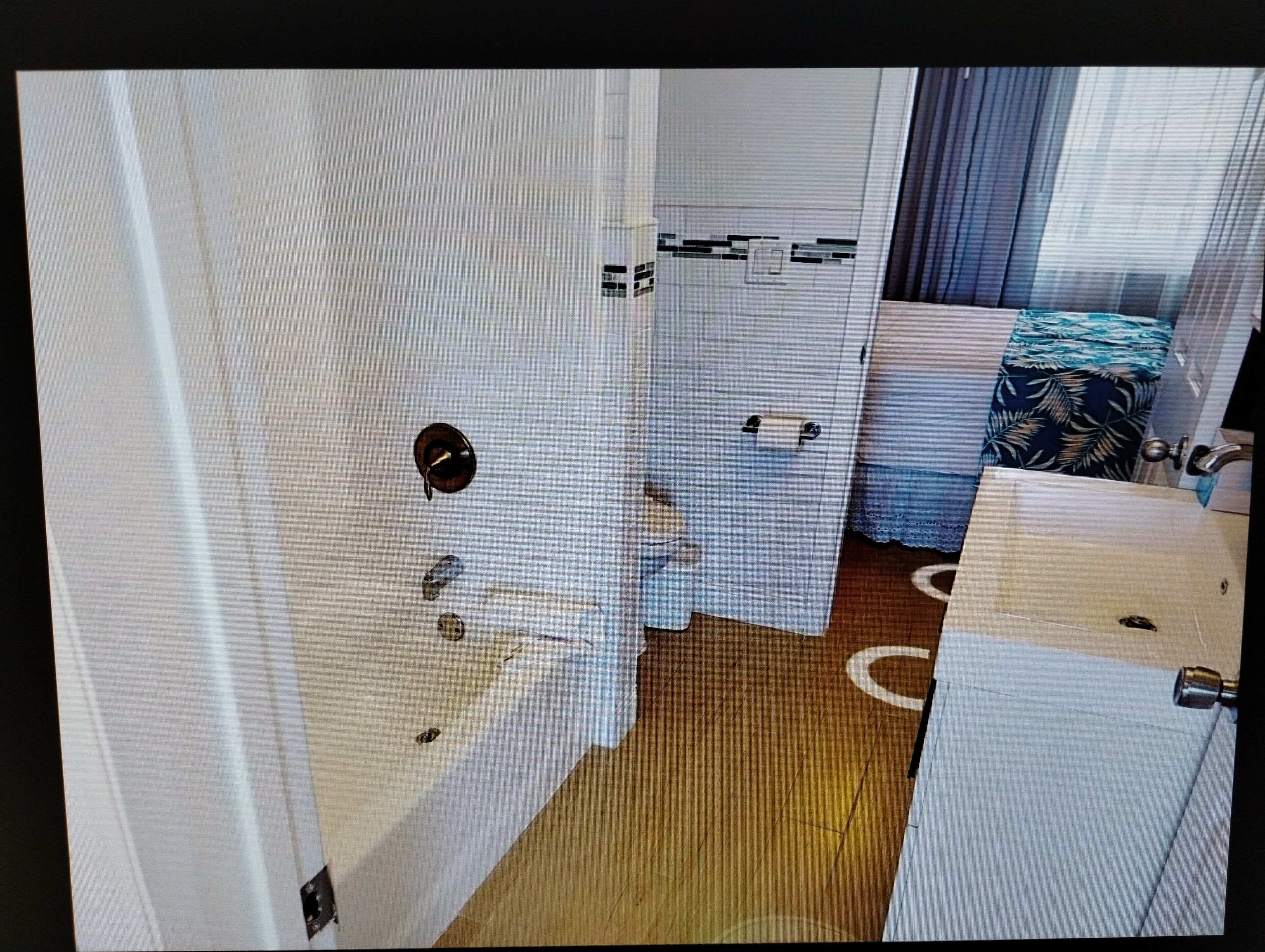 Un baño con bañera, inodoro y lavamanos.