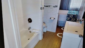 Un baño con bañera, inodoro y lavamanos.