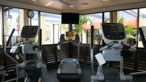 A gym with treadmills, elliptical machines, and a stationary bike.
