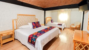 A hotel room with two beds, wooden furniture, a brick ceiling, and a large window. - Hotel Hacienda Montesinos (Morelia)